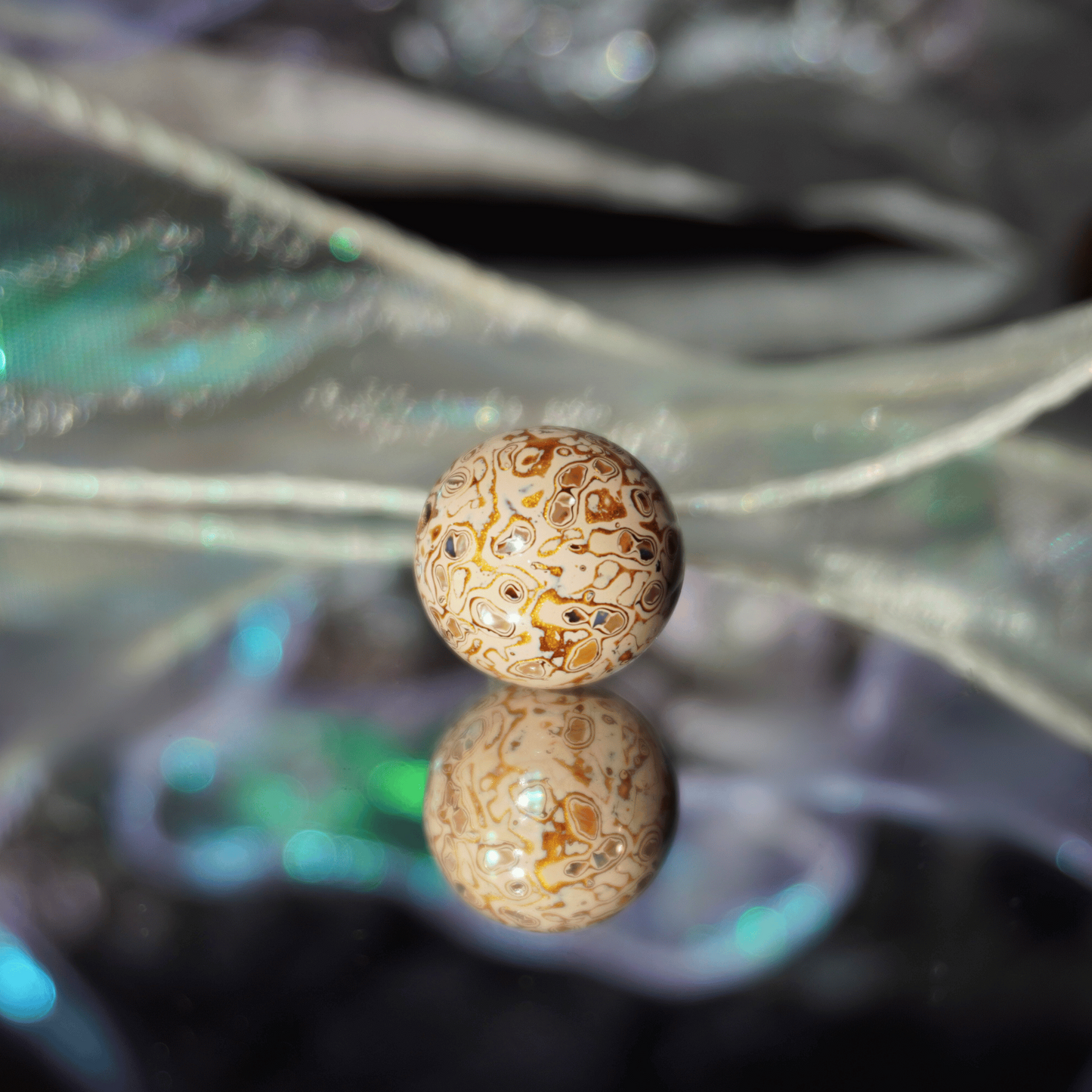 Desert Fortune ritual bead with burnished gold-copper tones, botanical resin_on_a_mirror