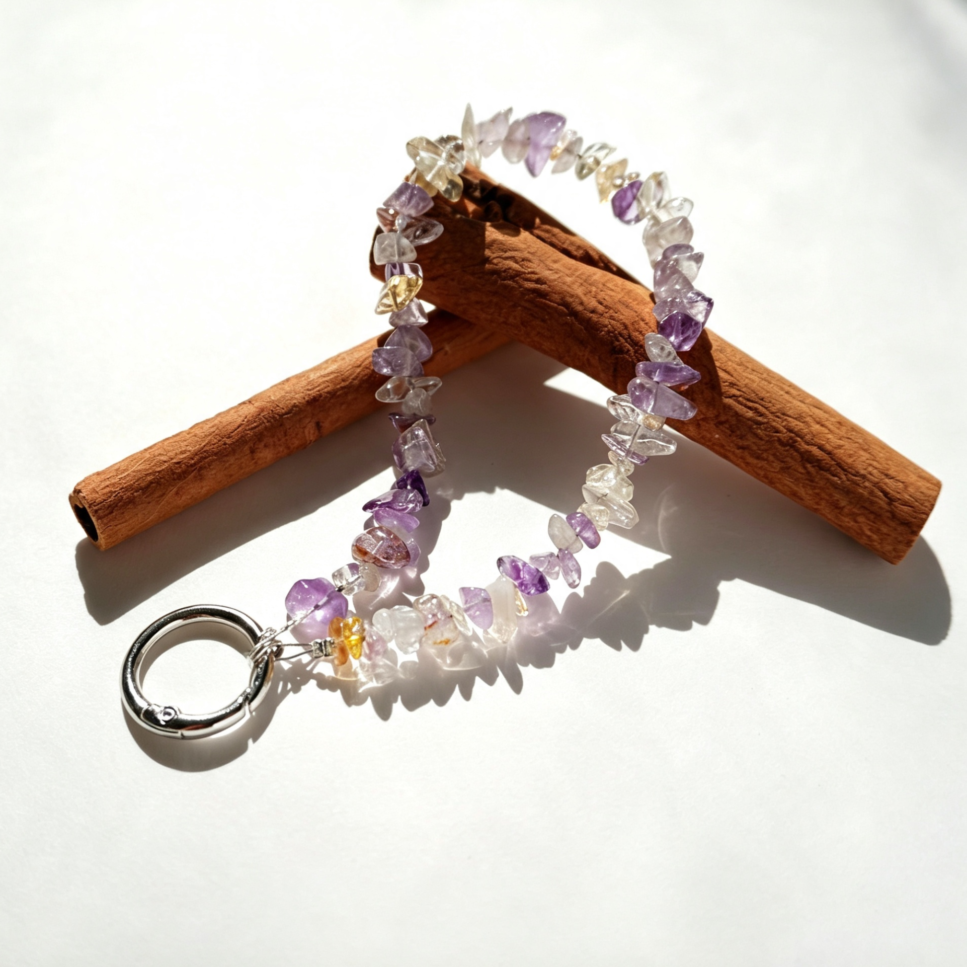 Purple quartz phone charm on cinnamon sticks