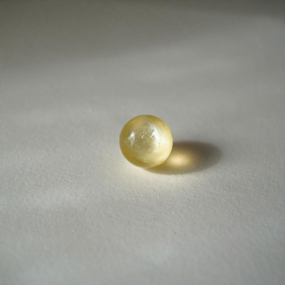 Perle Chardonnay en lépidolite dorée photographiée à la lumière du soleil