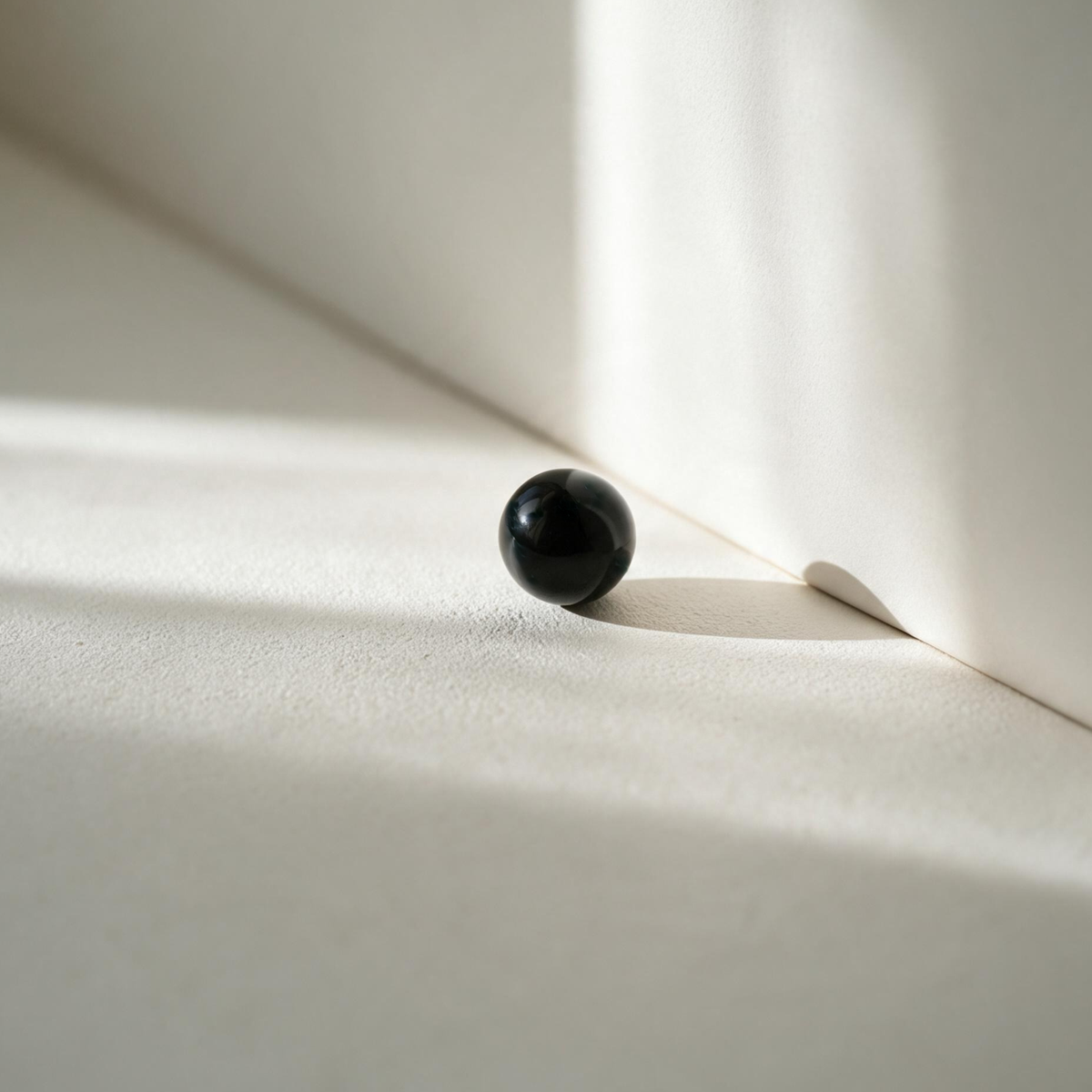 Une perle d'agate noire polie, à la surface brillante et aux reflets subtils.
