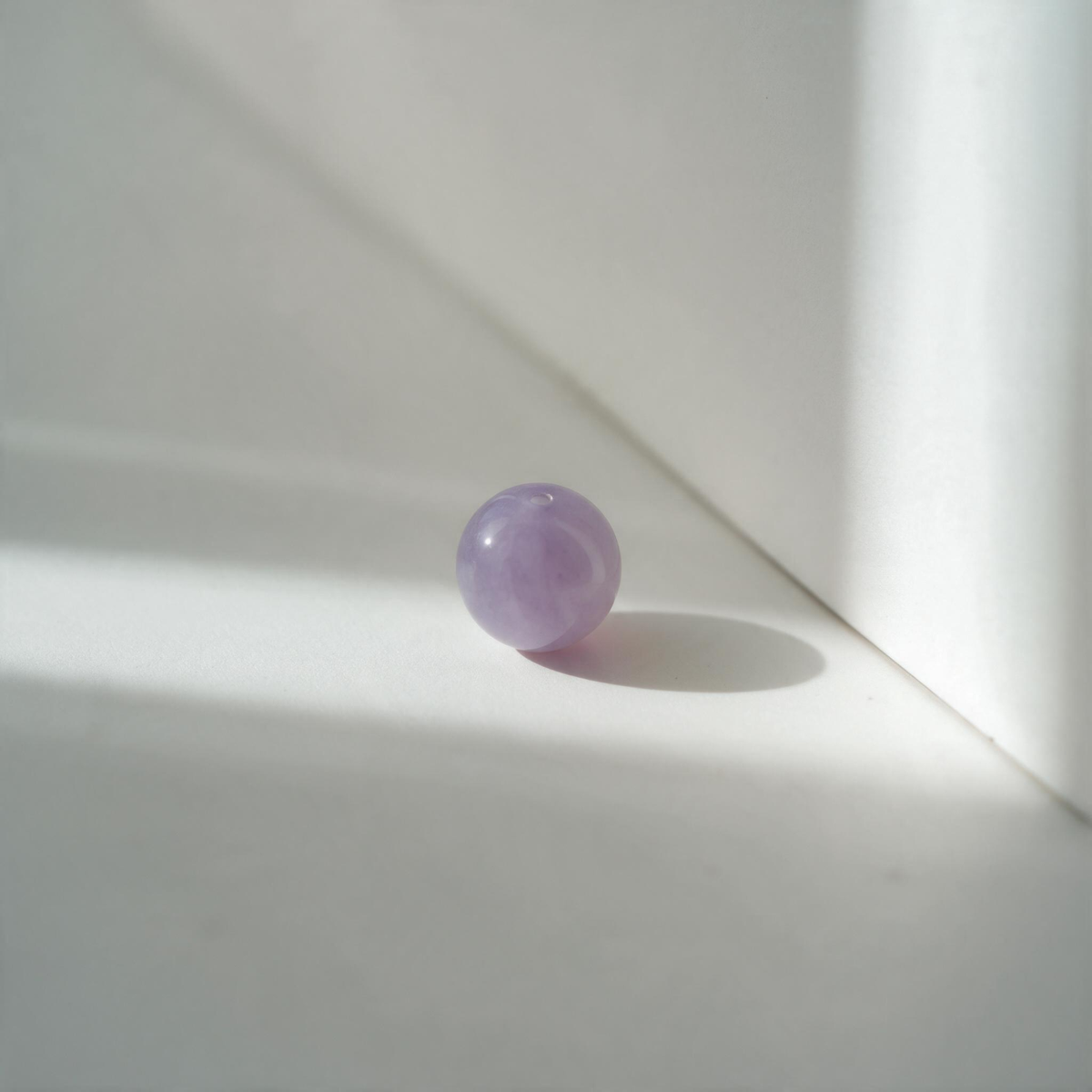 Gros plan sur une perle violette aux nuances de lilas fumé – collection Félins