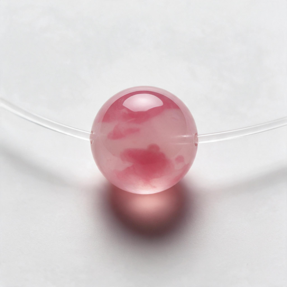 Gros plan sur la teinte rose et la surface polie de la perle Rosé