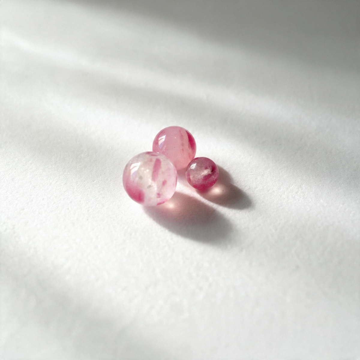 Plusieurs perles Rosé réunies, montrant leurs variations de teinte et de transparence