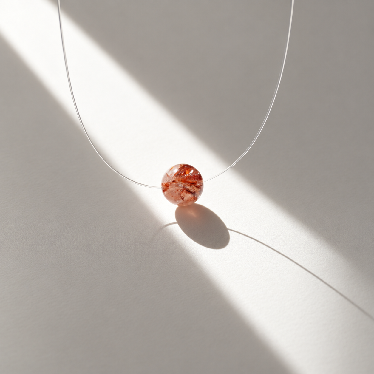 Perle Syrah en quartz à inclusions rouges photographiée à la lumière du soleil